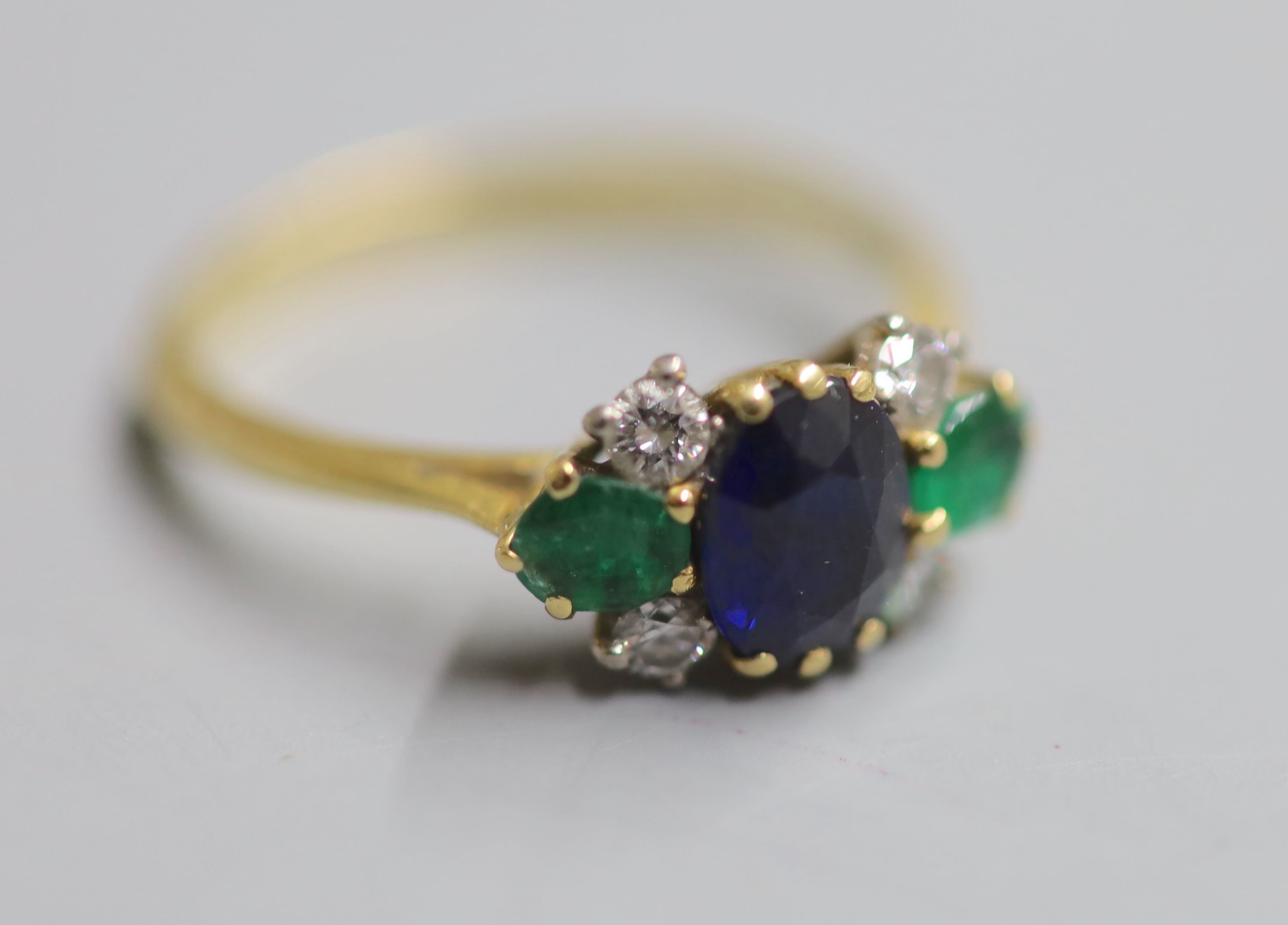 A 1970s 18ct gold, sapphire, emerald and diamond cluster ring, size P/Q, gross 3.2 grams.